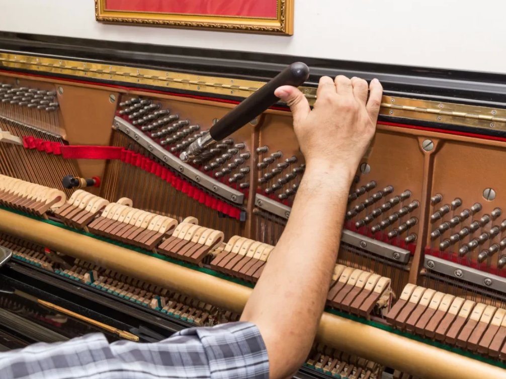 Singapore Piano Shop experienced piano technician at work on a grand piano